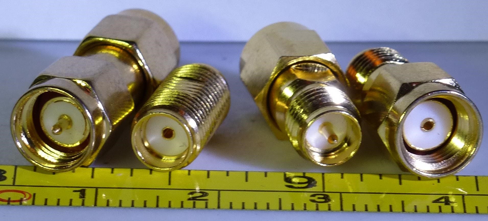 Four SMA and RP-SMA connectors arranged side by side showing the differences between male and female variants of each type.
