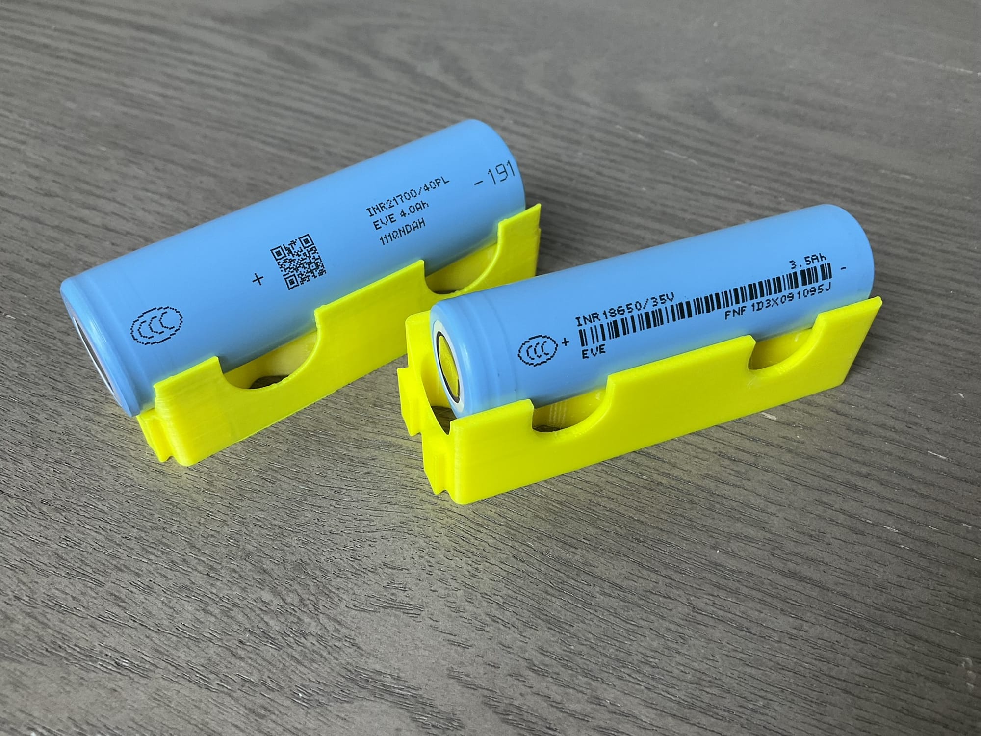 An 18650 and 21700 lithium-ion cylindrical battery cell side by side for comparison.