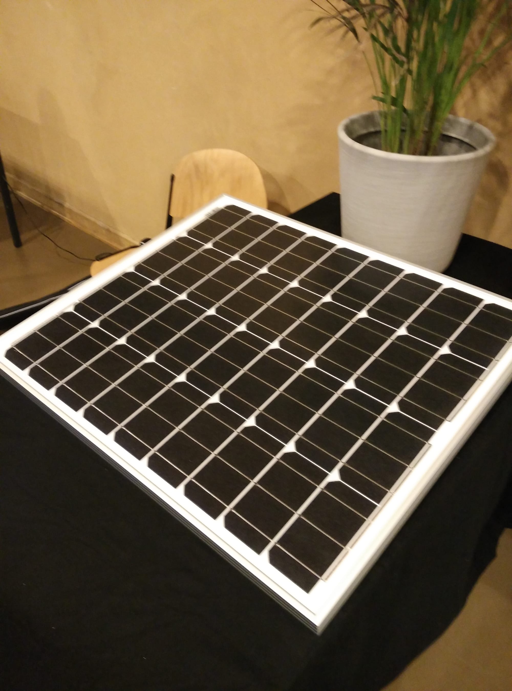 A small monocrystalline silicon solar panel showing the characteristic uniform dark cells.