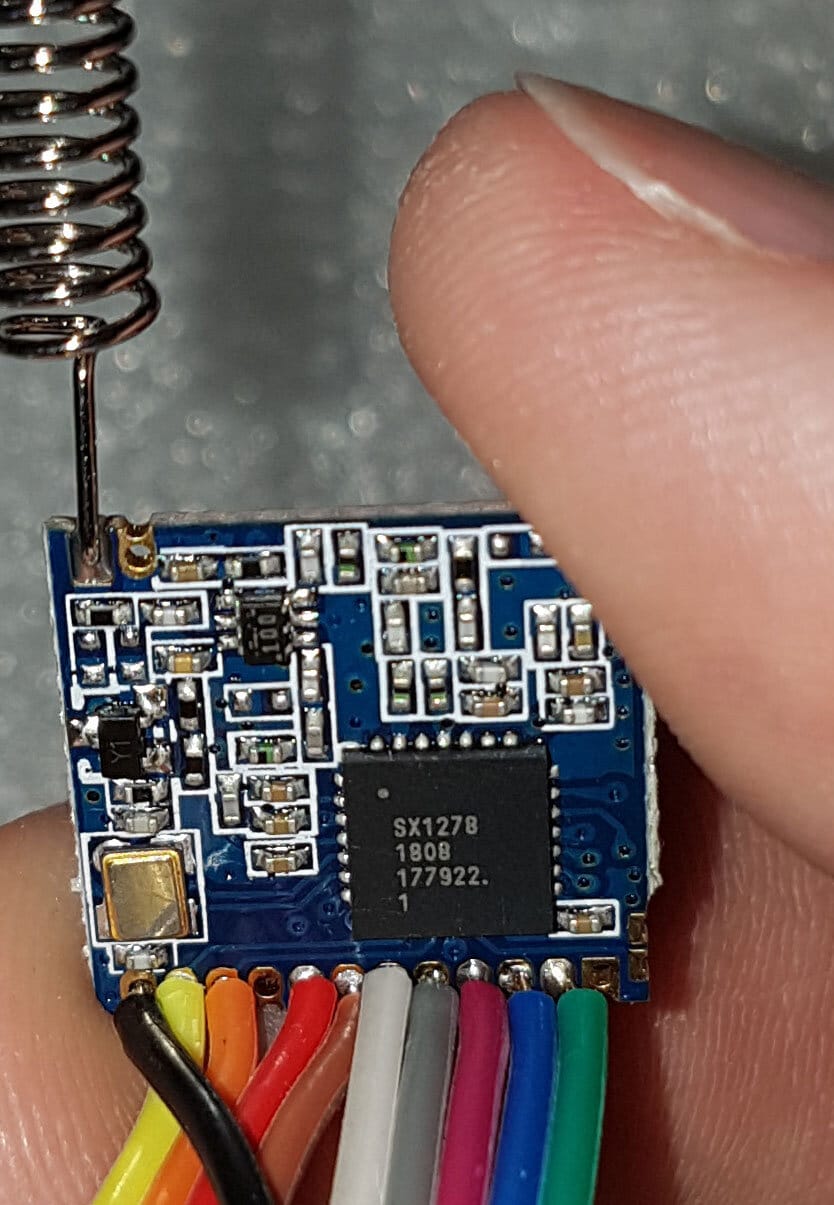A bare LoRa radio module with its antenna and SPI wiring attached, the kind of hardware Reticulum talks to through an RNode interface.